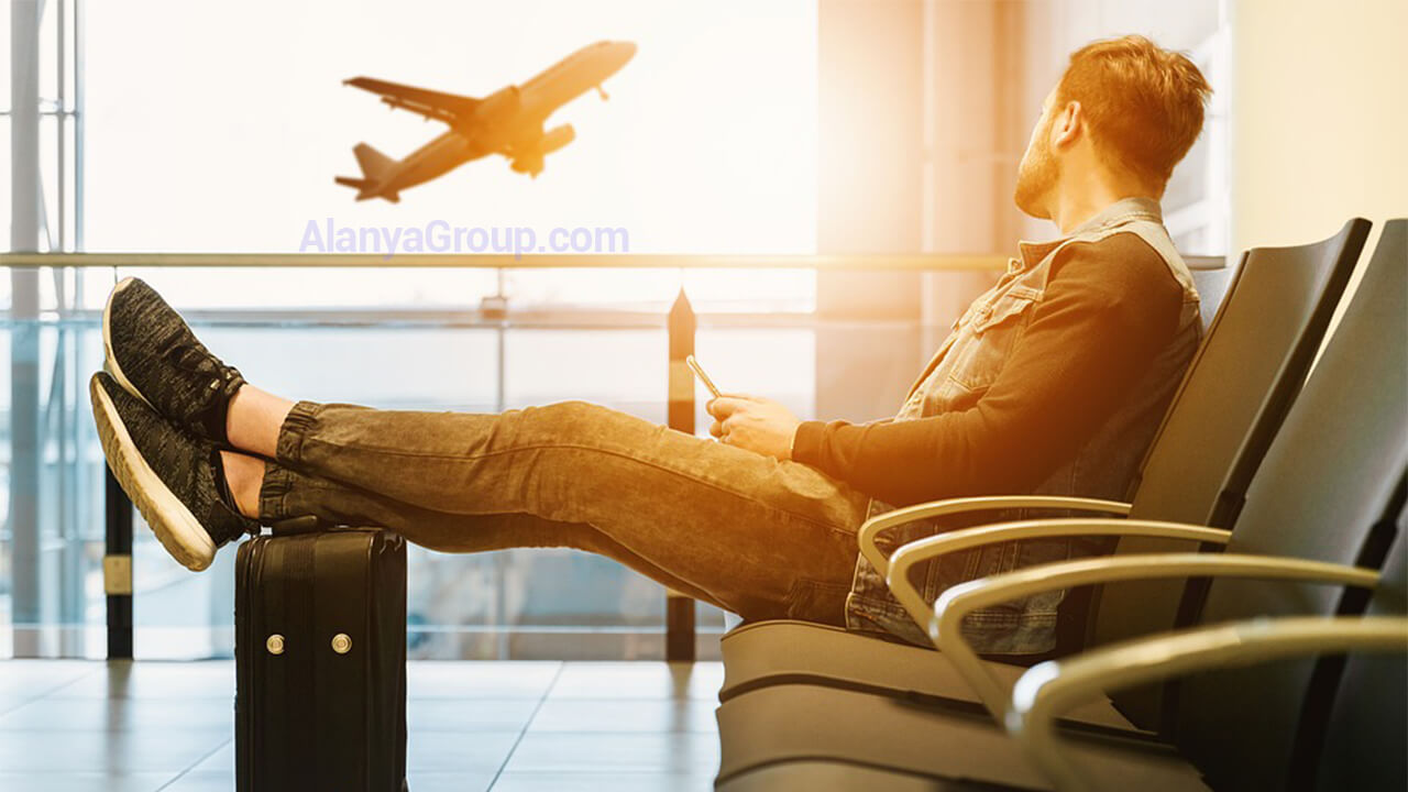 Traveler relaxing at the airport before a Belek 24/7 Airport Transfer with Alanya Group.